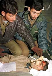 Policemen inspect the body of Javid Ahmad Bhat
