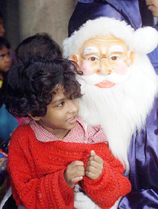 A man dressed as a Santa Claus holds an orphan