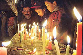 Devotees light candles to mark Christmas celebrations