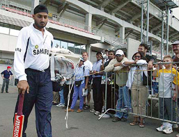 Indian spin bowler Harbhajan Singh walks past fans of the Indian cricket team at practice 
