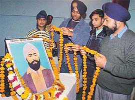 Residents garland the portrait of Shaheed Udham Singh during his birth anniversary celebrations organised in GGN Khalsa College, Ludhiana