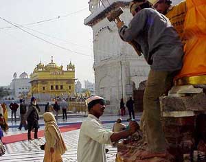 Craftsmen and devotees busy reconstructing Nishan Sahib