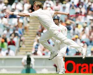 England's Jamie Foster watches as Australia's Brett Lee lunges to field a ball
