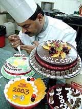 A chef decorates cakes