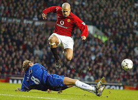 Manchester United's Juan Veron leaps over the challenge of Birmingham City's Robbie Savage for the ball 