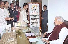 Mr Harvinder Kalyan, general secretary of the HPCC, presents a lifesize greeting card to Mr Bhajan Lal, president of the HPCC