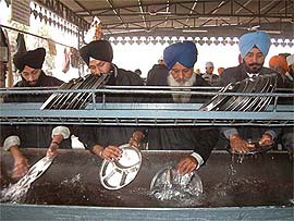 Members of the Sikh Forum, Punjab, and All India Sikh Student Federation (Amritsar)  clean utensils 