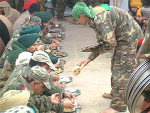 An army man serves at a "langar" at the border village of Muhawa, where an "akhand path" was held.