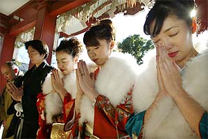 Foreign exchange brokers pray for a good year during a visit to a shrine in Tokyo on Monday, the first business day of the New Year