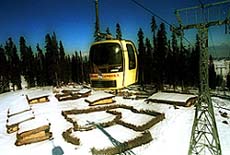 A cable car passes over snow-covered mud huts in Gulmarg 52 km northwest of Srinagar