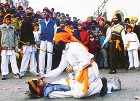 Devotees play 'gatka' during the nagar kirtan on the occasion of the birthday of Guru Gobind Singh