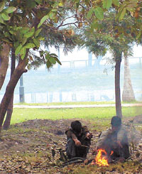 Labourers huddle around a bonfire in the Raisina Hill area