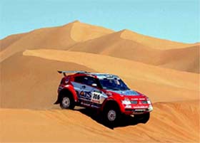 Stephane Peterhansel of France steers his Mitsubishi over sand dunes