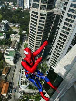 A man dressed as Spider-man climbs down the outside of a hotel