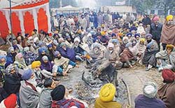 Braving the freezing cold, farmers block traffic on the Chandigarh-Jalandhar road, near Kharar, demanding payment of sugarcane dues
