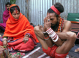 A sadhu performs yoga while begging on the banks of the Hooghly river