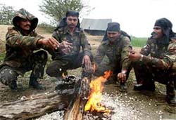 Soldiers posted on the border with Pakistan warm themselves in front of a fire near Amritsar