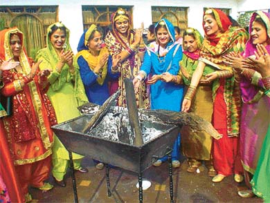 Members of the Gayatri Ladies Club gather around a bonfire to celebrate Lohri