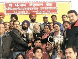 Punjab National Bank general manager S. K. Awasthi and deputy general manager P. L. Madan with the winners of the PNB Inter-Zone Sports Meet at the Karnail Singh Stadium on Saturday.