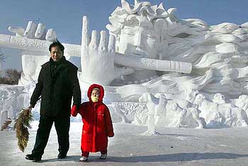 Visitors to an ice sculpture festival walk past a giant sculpture