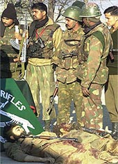 Soldiers stand behind the bodies of Lashkar-e-Toiba militants