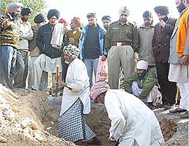 The body of Dalip Kaur being exhumed as officials of the district administration stand by and watch the proceedings in Seona village, near Patiala
