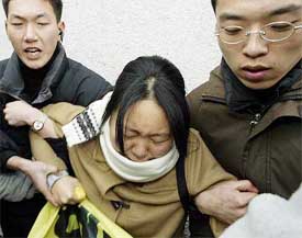 South Korean plainclothesmen detain a student protester near the US embassy in Seoul