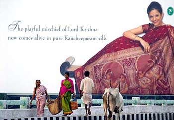 Pedestrians walk past a billboard advertising silk in Chennai on Tuesday.