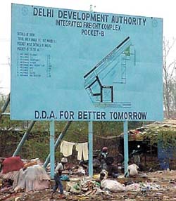 Scavengers sift through the garbage which continues to pile up under the huge signboard of the Delhi Development Authority near Gazipur in East Delhi.