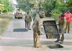 Potholes on the road leading to the Indian National Lok Dal election office in Sector 6 being repaired by HUDA employees in violation of the model code of conduct.