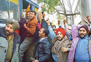 Chandigarh Police personnel arrests panchayat secretaries in Sector 17, Chandigarh, on Wednesday.