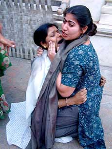 Two women cry after the arrest of their relatives