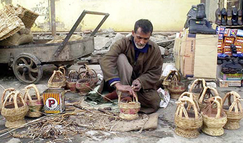A Kashmiri mends kangri
