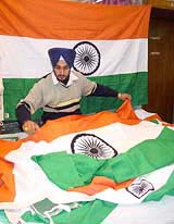 A shopkeeper in Jalandhar stitches new stocks of national flags