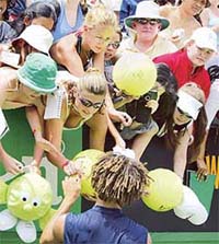 James Blake of the USA autographs large tennis balls after his match against Jose Acasuso of Argentina at the Australian Open