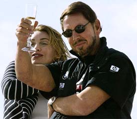 Oracle BMW Racing head Larry Ellison (R) and his fiance Melanie Croft toasts his crew after they defeated Swiss entrant Alinghi