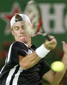 Lleyton Hewitt of Australia hits a forehand return to countryman Todd Larkham