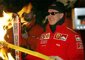 Formula One World Champion Michael Schumacher of Germany lights a torch before going on a night ski