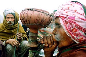 An old peasant woman smokes tobacco