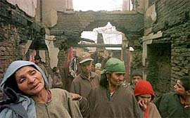 A woman weeps near the debris of her house