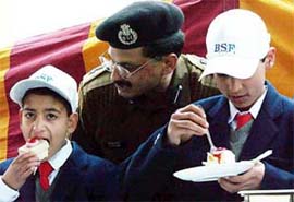 A BSF officer whispers sweet nothings in children's ears