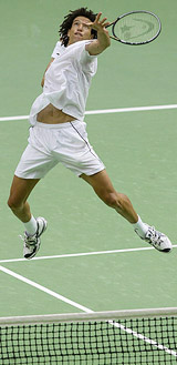 Younes El Aynaoui of Morocco goes for a smash against Lleyton Hewitt of Australia at the Australian Open