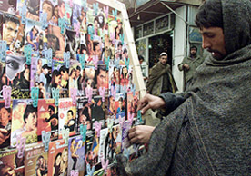 An Afghan man sorts out digital video discs