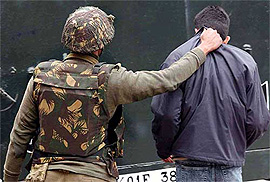 A BSF jawan takes away a suspected youth