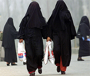 Kashmiri Muslim burqa-clad women walk at a busy market place