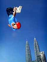 Against the Petronas Twin Towers, the world's tallest buildings, 13-yr-old Rian Arnold of Australian performs an inline skating jump