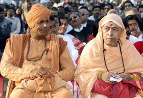 Hindu priests listen to a speaker at a rally