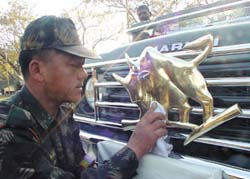 An Army jawan gives a shine to the emblem on the staff car of the Chief of the Army Staff at the Republic Day press preview at India Gate on Wednesday.