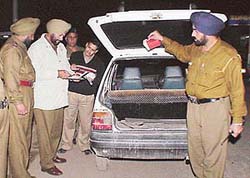 Police officials search vehicles at a surprise naka set up in Industrial Area, Phase II, as part of sealing plan for the city on Thursday night.
