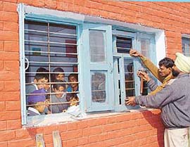 Staff members of the maintenance wing replace windowpanes in a government school 